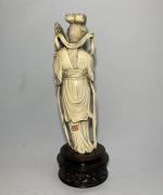 CHINE
Okimono en ivoire sculpté représentant une femme tenant un instrument...