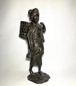 JAPON
Paysanne en bronze patiné portant un panier sur son dos,...
