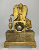 PENDULE en bronze doré représentant Iris s'attachant les ailes, assise...