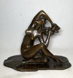 SUJET en bronze patiné représentant une femme alanguie, signé et...