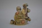 CHINE
Sujet en ivoire représentant un personnage assis tenant des paniers...