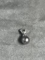 PENDENTIF or gris sertie d'une perle noire, la monture pavée...