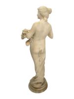 SCULPTURE en marbre représentant une femme partiellement dénudée ramassant des...