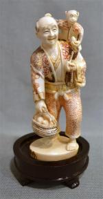 JAPON
Ivoire polychrome sculpté représentant un homme au panier et au...