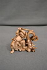 JAPON
Okimono en ivoire à patine jaune, Benkei terrassant un dragon...