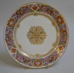 SEVRES
Assiette ronde en porcelaine à décor polychrome et or aux...