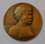 L. DESVIGNES Médaille ronde en bronze représentant une jeune portant...