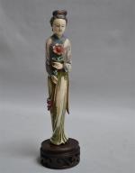 JAPON
Sujet en ivoire représentant une femme tenant une fleur, traces...
