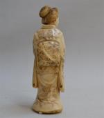 JAPON
Sujet en ivoire sculpté figurant une femme tenant une paire...