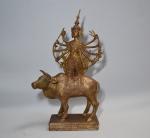INDE
Groupe en bronze doré représentant une divinité sur une vache
H.:...